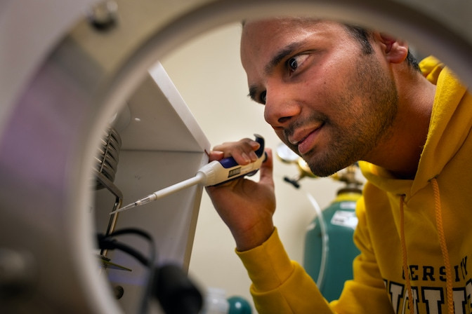 Postdoctoral researcher Sudeep Sharma adding droplets of water to a cooling unit