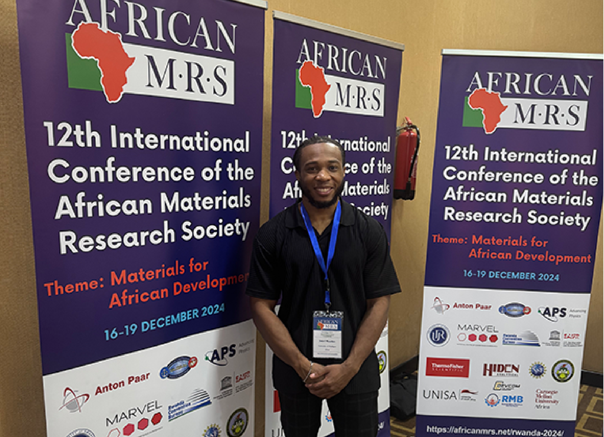 VetIF Fellow Jebril Thaxton standing in front of AMRS conference banners