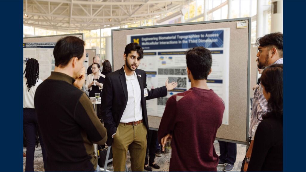 Graduate students engage in discussions with peers and faculty during the poster session.